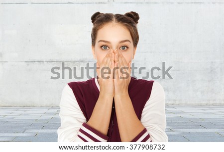 people, emotion, expression and teens concept - scared or confused teenage girl over gray urban street background