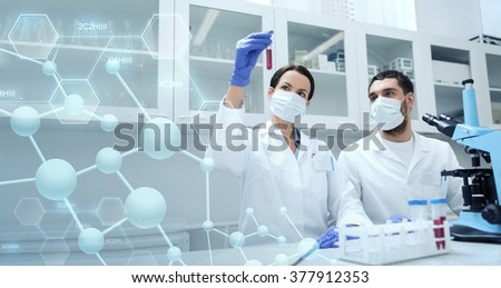 science, chemistry, technology, biology and people concept - young scientists with test tube and microscope making research in clinical laboratory over blue molecular structure background