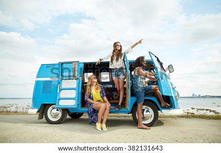summer holidays, road trip, vacation, travel and people concept - smiling young hippie friends in minivan car on beach
