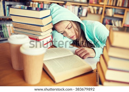 people, education, session, exams and school concept - tired student girl or young woman with books and coffee sleeping in library