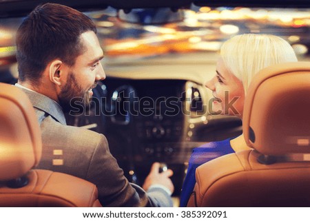 love, luxury, nightlife, automobile  and people concept - happy couple driving in cabriolet car over night city lights background