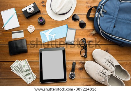 vacation, travel, tourism, technology and objects concept - close up of gadgets and traveler personal stuff