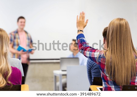 education, high school, teamwork and people concept - group of students raising hand in lecture hall