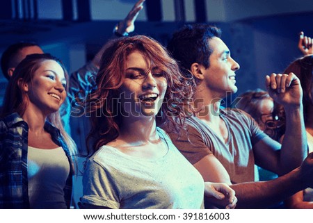 party, holidays, nightlife and people concept - happy friends dancing at night club