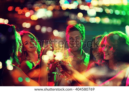 party, holidays, celebration, nightlife and people concept - smiling friends clinking glasses of champagne in night club with holidays lights