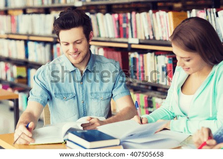 people, knowledge, education and school concept - group of happy students with books preparing to exam in library