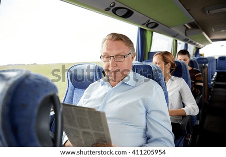 transport, tourism, trip and people concept - senior man reading newspaper in travel bus