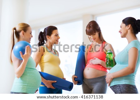 pregnancy, sport, fitness, people and healthy lifestyle concept - group of happy pregnant women with sports equipment talking in gym