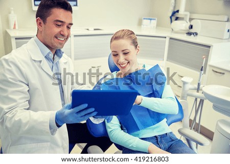 people, medicine, stomatology and health care concept - happy male dentist showing tablet pc computer to woman patient at dental clinic office