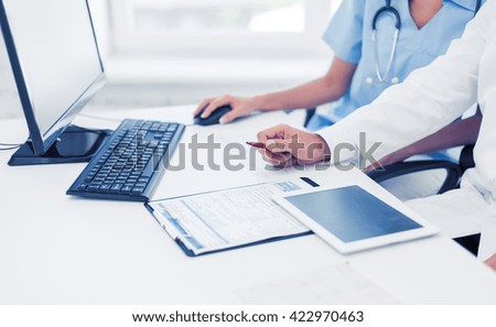 healthcare, medical and technology concept -  group of doctors looking at tablet pc