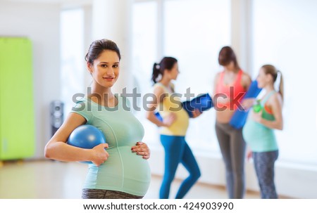 pregnancy, sport, fitness, people and healthy lifestyle concept - happy pregnant woman with ball in gym