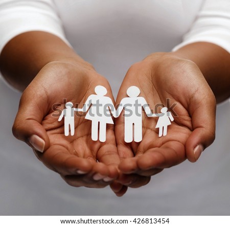 life insurance, love and charity concept - closeup of womans cupped hands showing paper man family