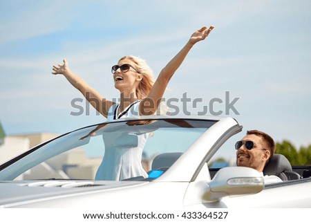 transport, leisure, road trip and people concept - happy man and woman driving in cabriolet car outdoors