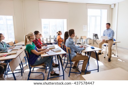 education, school and people concept - group of happy students and teacher with papers or tests