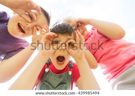 summer, childhood, leisure and people concept - group of happy kids having fun and making faces outdoors
