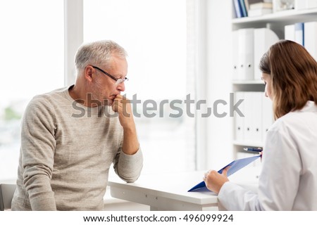 medicine, age, health care and people concept - senior man and doctor with clipboard meeting in medical office at hospital