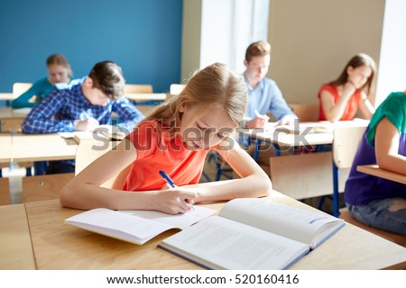 education, learning and people concept - student girl with book writing school test