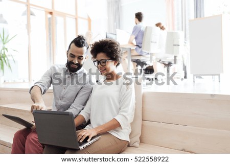 business, startup, technology and people concept - happy international creative team with laptop and tablet pc computer at office