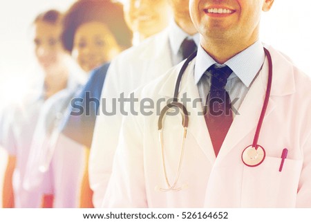 health care, profession, people and medicine concept - close up of happy doctors with stethoscope at hospital