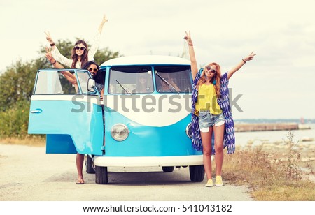 summer holidays, road trip, vacation, travel and people concept - smiling young hippie friends over minivan car