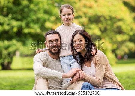 family, parenthood, adoption and people concept - happy mother, father and little girl in summer park