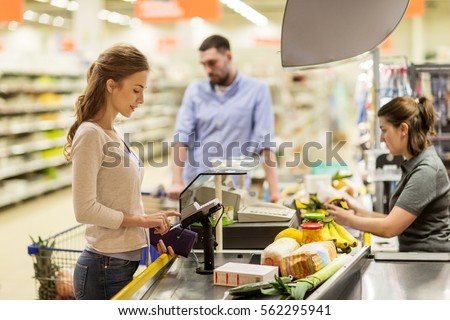 shopping, sale, consumerism, cashless payments and people concept - happy woman buying food at grocery store or supermarket cash register