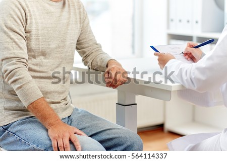 medicine, old age, healthcare and people concept - close up of senior man and doctor meeting in medical office at hospital
