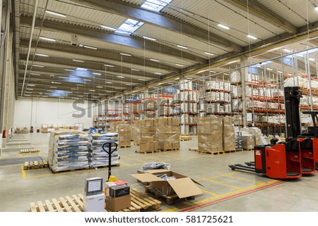 logistic, storage, shipment, industry and manufacturing concept - forklift loader and cargo boxes storing at warehouse