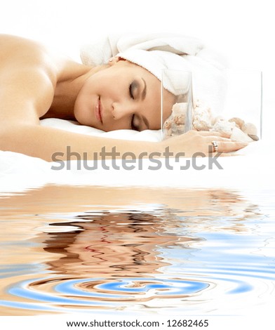 beautiful lady with sea shells in glass cube on white sand