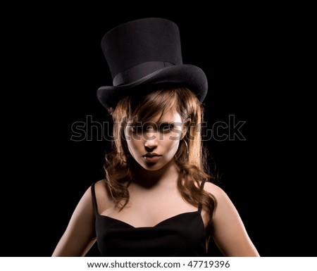 dark picture of woman in black dress and top hat