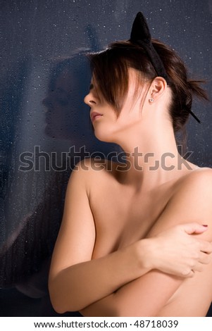 sad woman with cat ears at the rainy window
