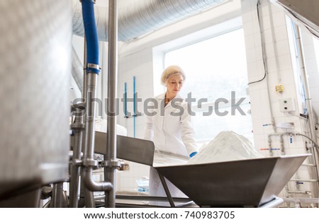 manufacture, industry, food production and people concept - woman working at ice cream factory conveyor with powdered milk