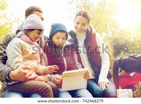 travel, tourism, hike and technology concept - happy family with tablet pc computer and backpacks at camp in woods