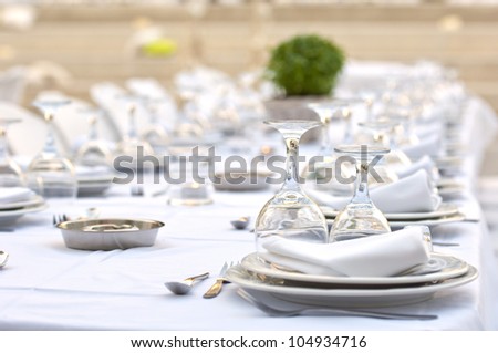 a close-up of  a formal dinner table with ashtrays in the middle