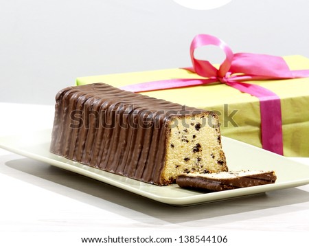 chocolate chip cake on a table in front of a present for a party