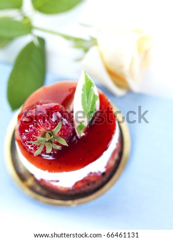 a strawberry cheese cake and a yellow rose