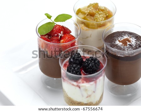 a variety of desserts,a chocolate mousse with strawberries,a cheese cake with raspberries,a double chocolate mousse and a cheese cake with peach