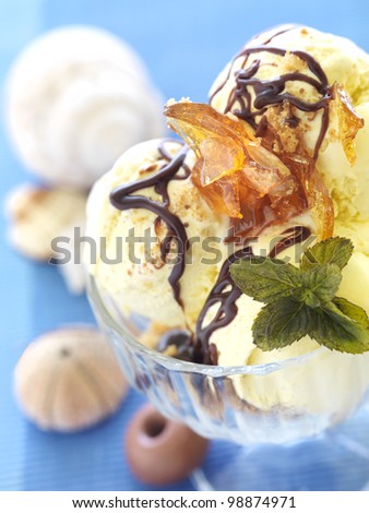 three scoops of caramel ice cream decorated with fresh mint and caramel pieces