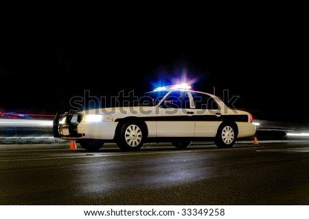 Traffic police car with lights on & motion blur behind it