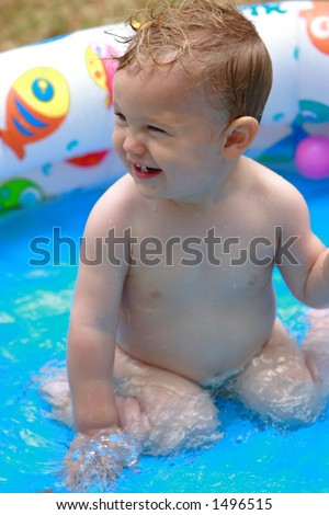 A toddler in a kiddie pool [approx. 18 mos]
