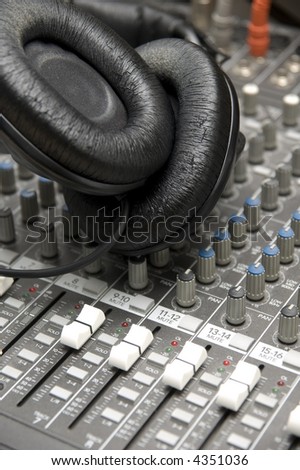 closeup view of a DJ\'s mixing desk with a pair of headphones