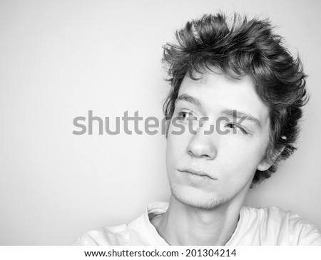 Black and white portrait of young man thinking and looking away left.