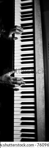 two hands play on piano. Black and white shot.