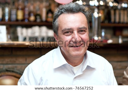 Man in shirt looking in camera and smile.