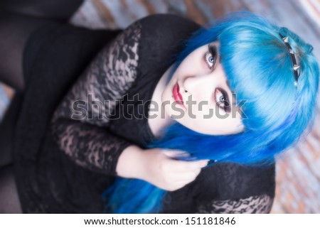 Beautiful young woman with blue hair looking up