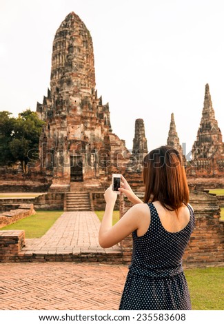 female using smart-phone at sight seeing place  in Thailand ancient temple