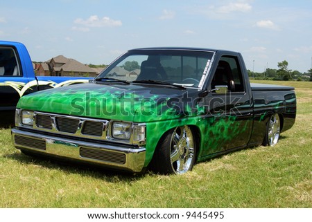 stock photo Lowrider Nissan truck with green flames