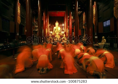 Buddhist monk kneels down prayer in temple