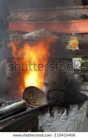 Heat in ancient metal crucible , Ancient metal cast for buddha statue  in Lok Molee Temple, Chiangmai, Thailand.
