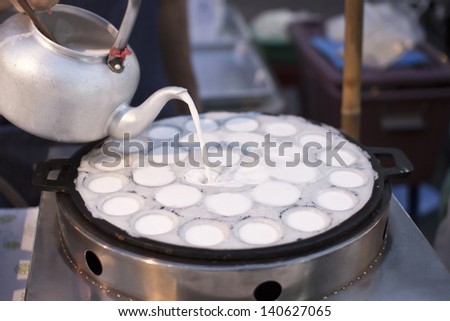 Man fill Coconut milk mix with powder on pan , Kind of Thai sweetmeat fried dessert